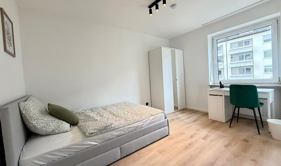 Schlafzimmer mit Schreibtisch und Blick ins Grüne