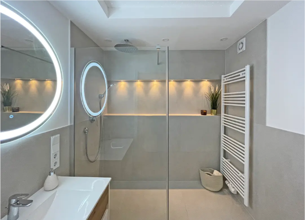 Badezimmer mit beleuchtetem Rundspiegel